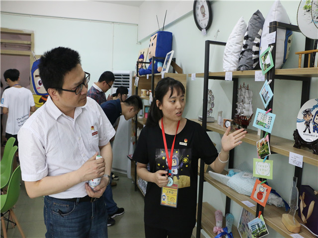 1493872371239669.jpg 康美-学生向党委副书记李彬源介绍闽小科工作室.jpg