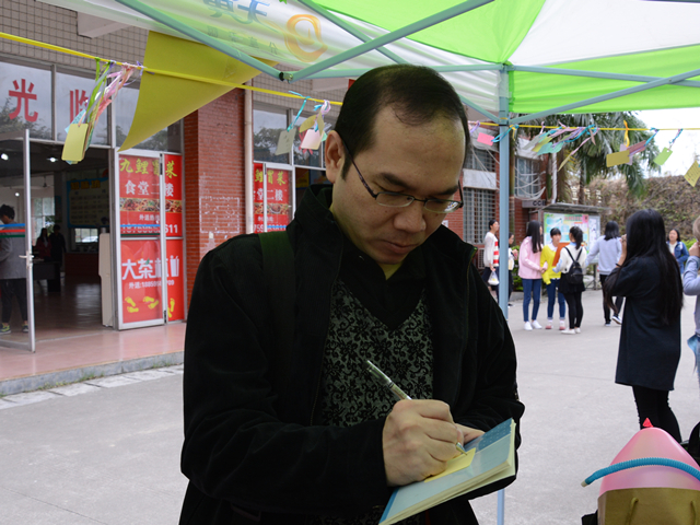 1480048807848889.jpg 美林-外语系副主任陈孔吉老师在写祝福语.jpg